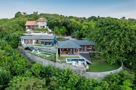 Aerial view of the three Treetop Heights villas on the green hillside
