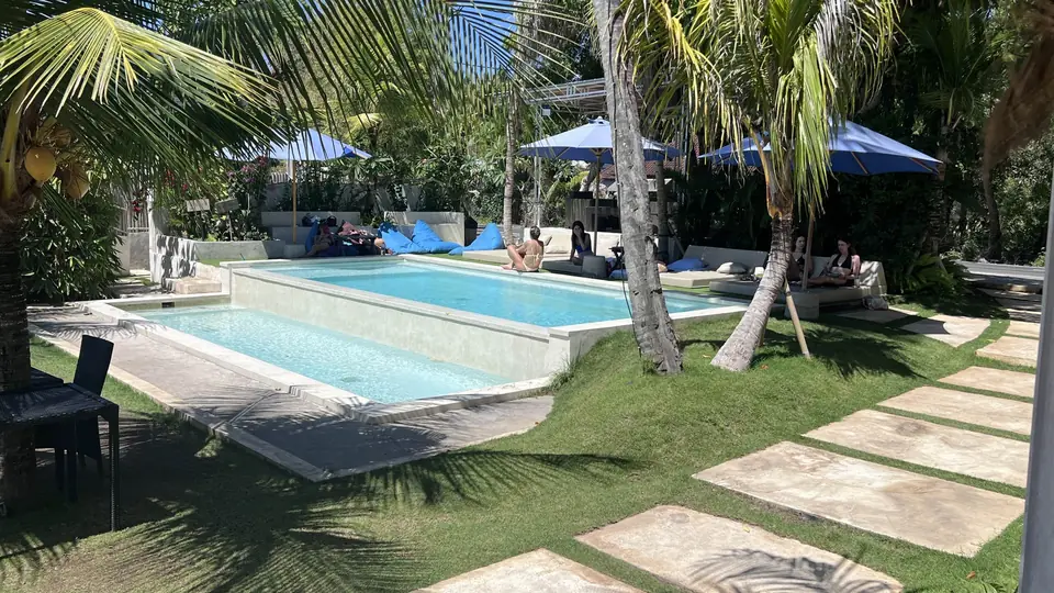 Singabu Beach Club pool shaded by palm trees