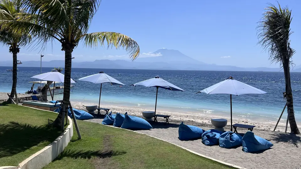 Sunbathers on Singabu beach looking out at Mount Agung