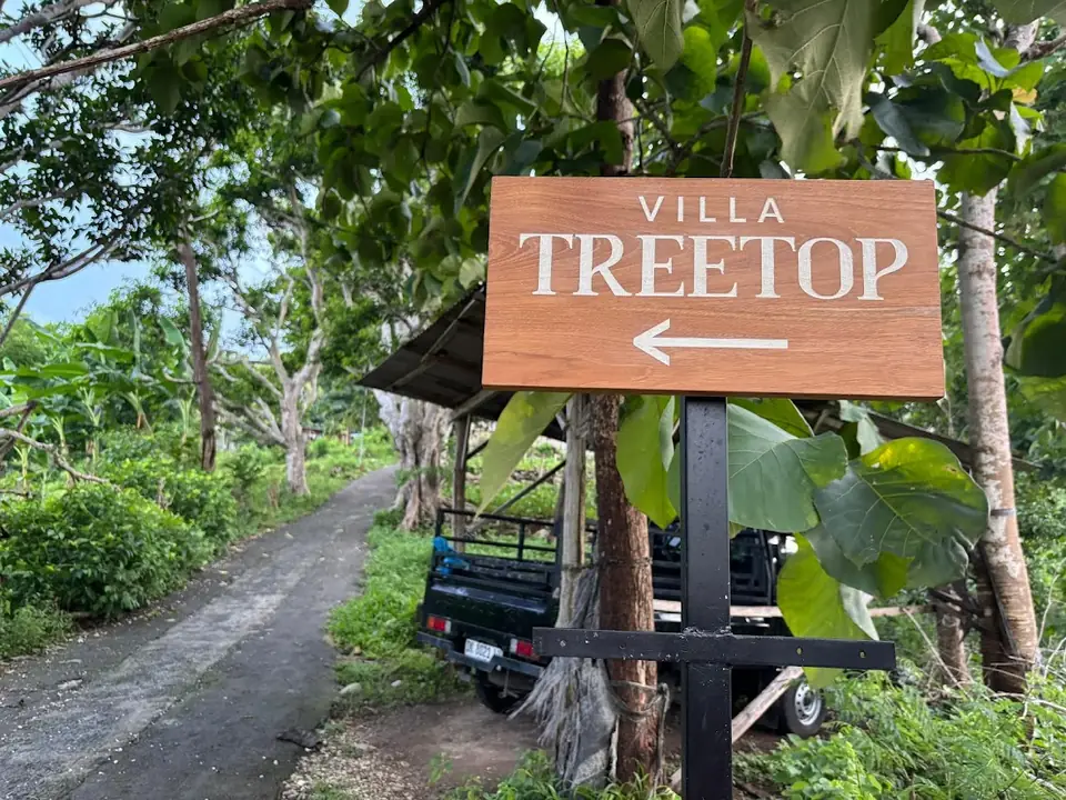 Wooden Villa Treetop sign with arrow pointing up the track